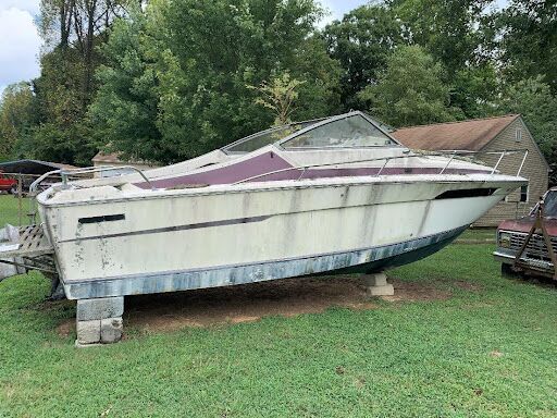 Abandoned boat in a backyard scheduled for removal by a boat disposal service